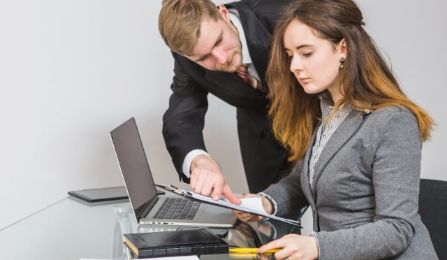 two-businesspeople-having-discussion-document