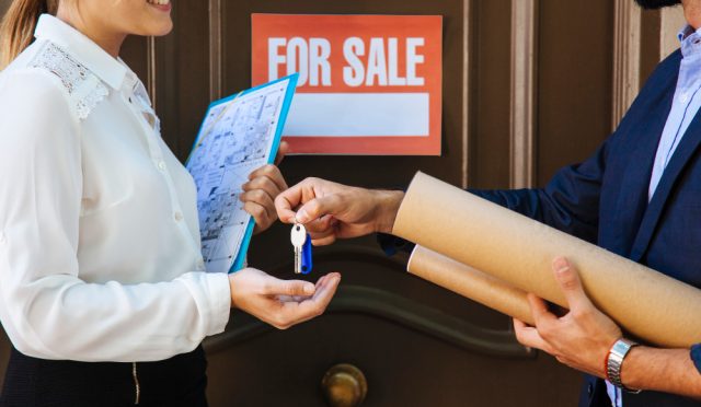 woman-receiving-key-from-real-estate-agent
