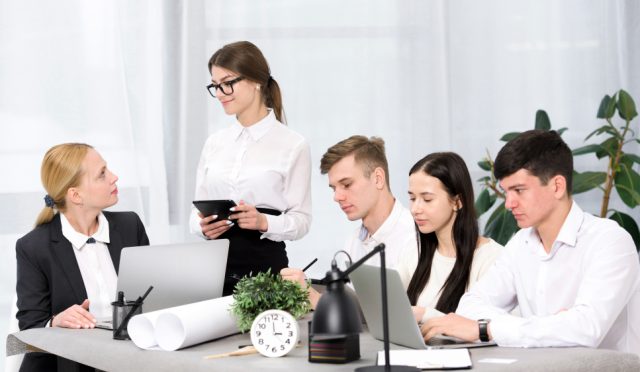 female-manager-discussing-project-with-her-colleagues-office