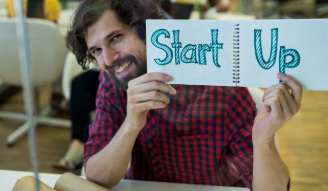 male-graphic-designer-holding-spiral-notepad-with-text