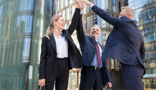 three-cheerful-businesspeople-giving-five-smiling-confident-happy-colleagues-celebrating-successful-deal-together-standing-outdoors-rising-hand-up-teamwork-partnership-concept - Kopya
